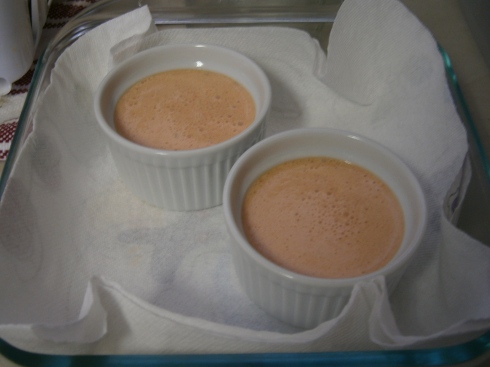 The custard is poured into ramekins, and they are given a hot water bath as they go into the oven.